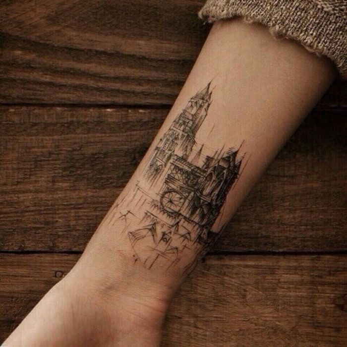 a person's arm with a small cityscape tattoo on the left wrist