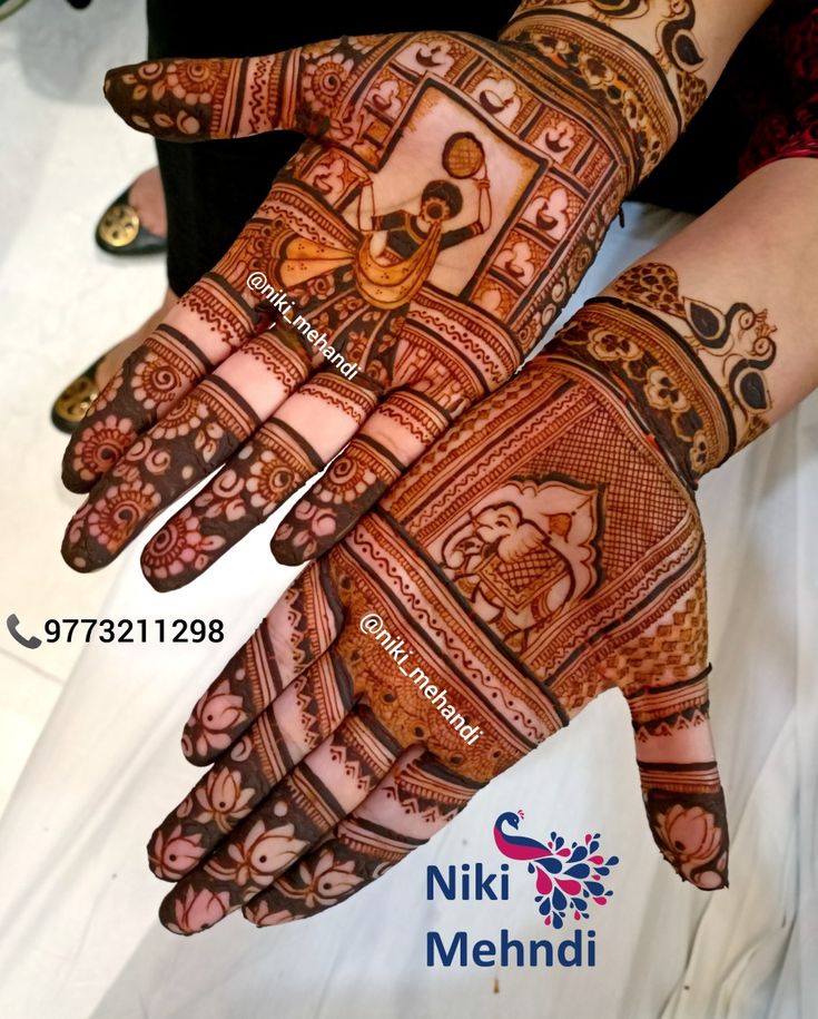 the hands are decorated with henna designs on it's palms and fingers,