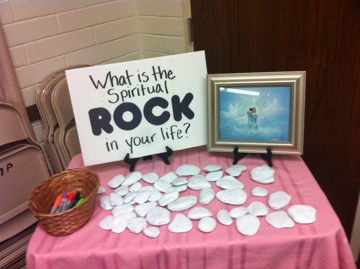 a pink table topped with white rocks and a sign that says what is the spiritual rock in your life?