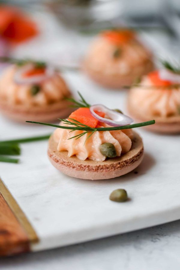 small appetizers are arranged on a white plate with green garnishes