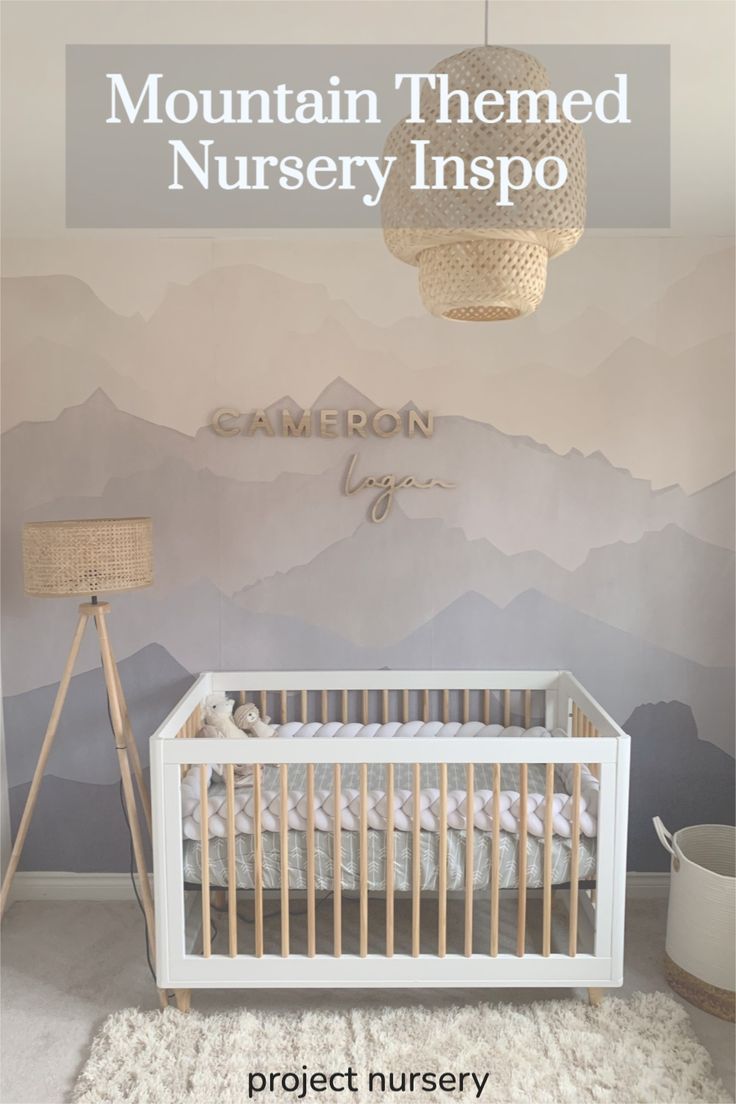 a baby's room with mountains painted on the wall and a white crib