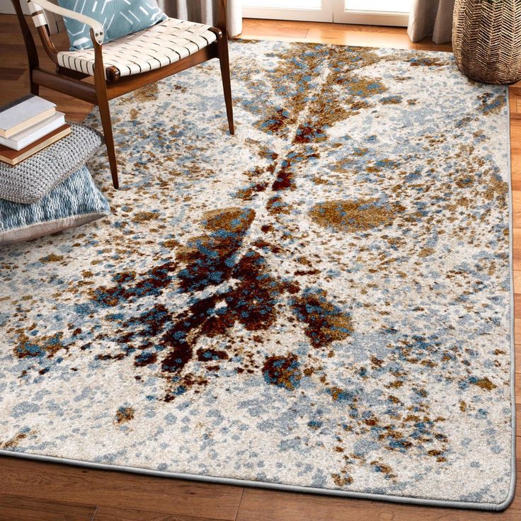 a large rug with an abstract design on the floor in front of a chair and window