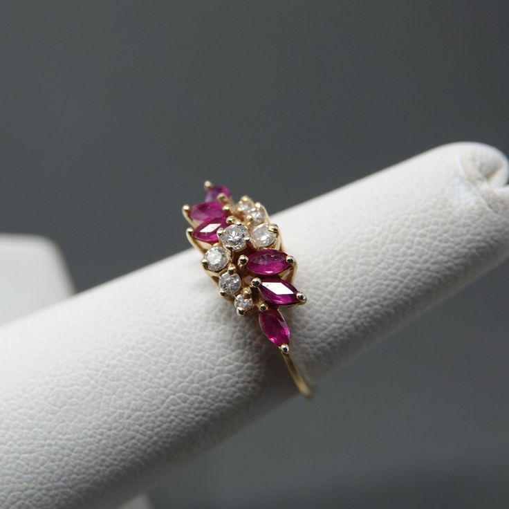 "Makes one nice cocktail ring. 6 marquis cut rubies. 7 round cut diamonds. Marked exquisite , 14K and maker's mark \"W\". 1.58 dwt. Little to no wear" Wedding Ruby Ring With Vvs Clarity Marquise Cut, Marquise Ruby Ring With Diamonds, Fine Jewelry Ruby Ring With Diamond And Marquise Cut, Marquise Cut Ruby Ring With Diamond For Anniversary, Marquise Cut Ruby Diamond Ring With Prong Setting, Marquise Ruby Cluster Ring In Fine Jewelry Style, 14k Gold Marquise Cut Ruby Ring With Prong Setting, Red Marquise Cut Diamond Ring, Marquise Cut Ruby Ring For Anniversary