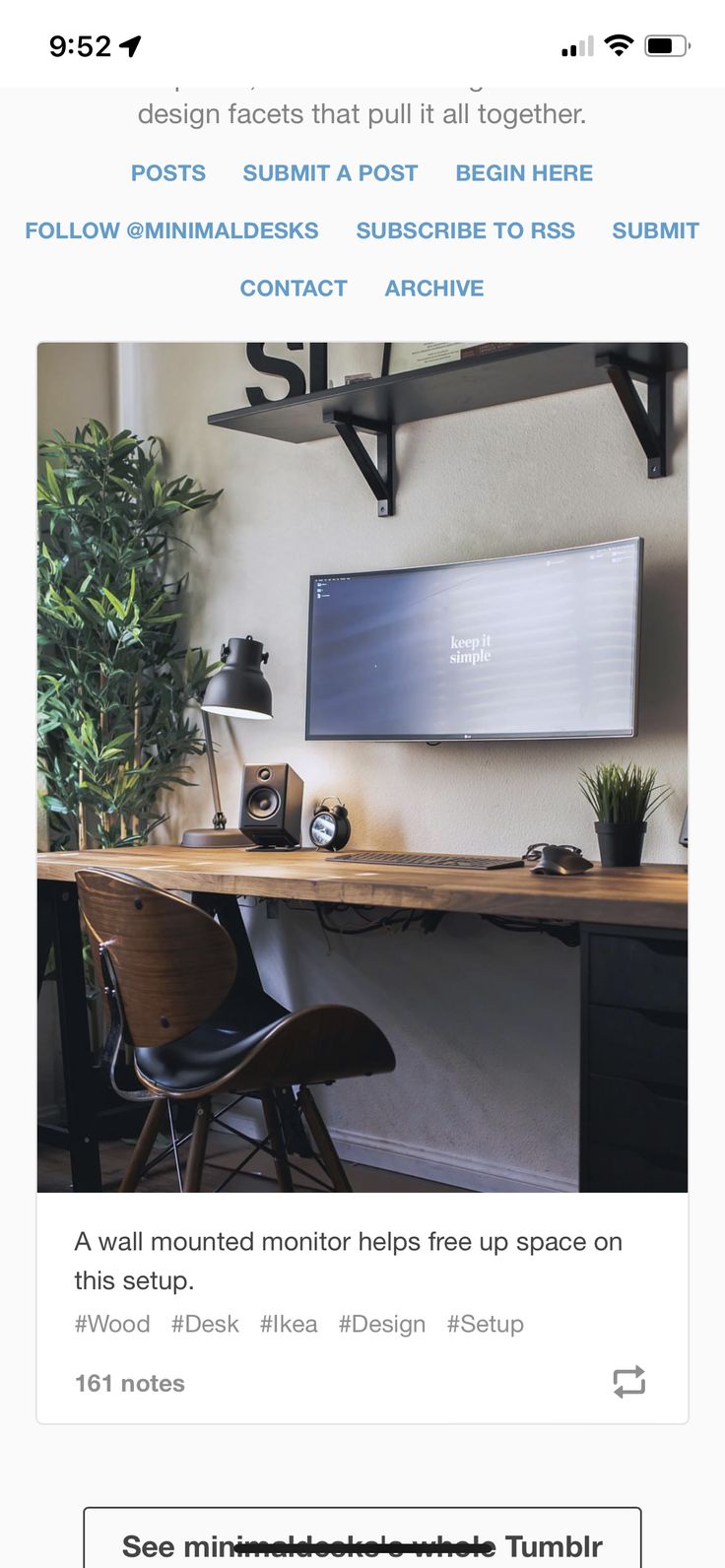 a computer monitor sitting on top of a wooden desk next to a black chair and potted plant