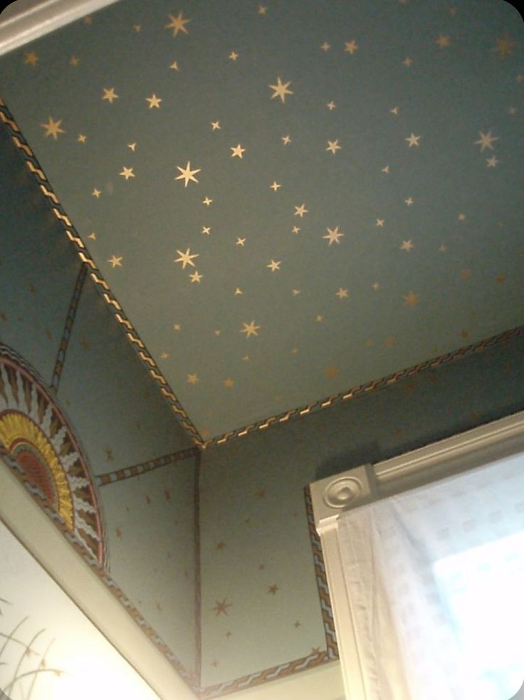 the ceiling has stars painted on it and there is a window in front of it