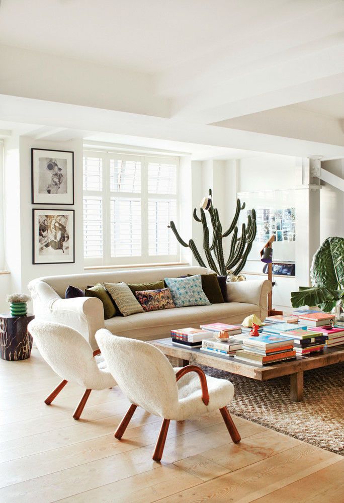 a living room filled with furniture and plants