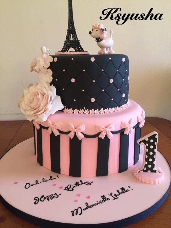 a birthday cake with the eiffel tower in the background and flowers on top