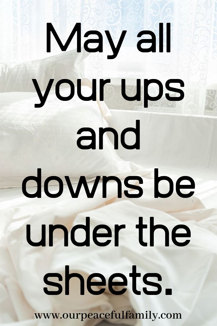 a bed with white sheets and pillows in front of a window that says, may all your ups and downs be under the sheets