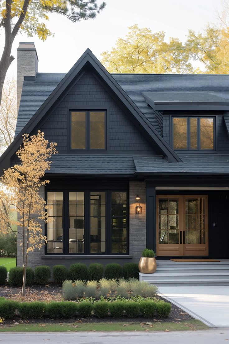 a black house with lots of windows and steps leading up to the front door is shown