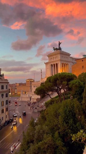 the view of an old european city at sunset with pink clouds in the sky above