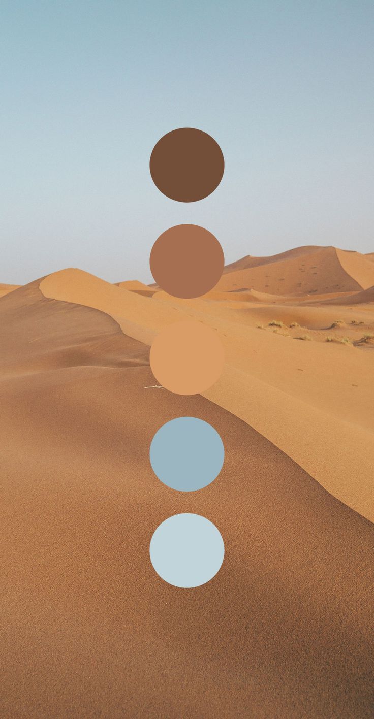 three circles are floating in the air over sand dunes, with blue and brown colors