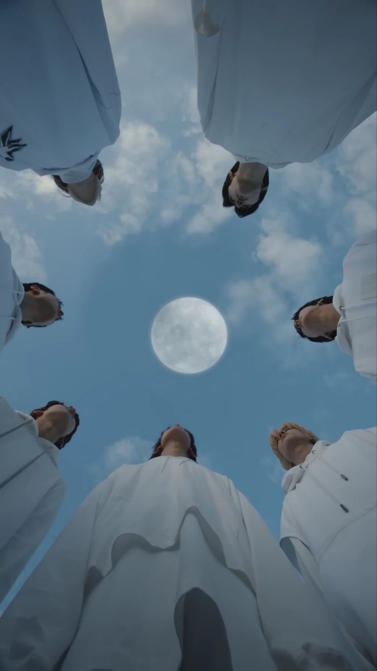 looking up at the sky from below, with clouds and moon in the distance behind them