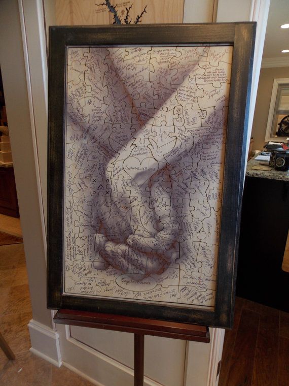 a couple holding hands in front of a framed photo with words written on the paper