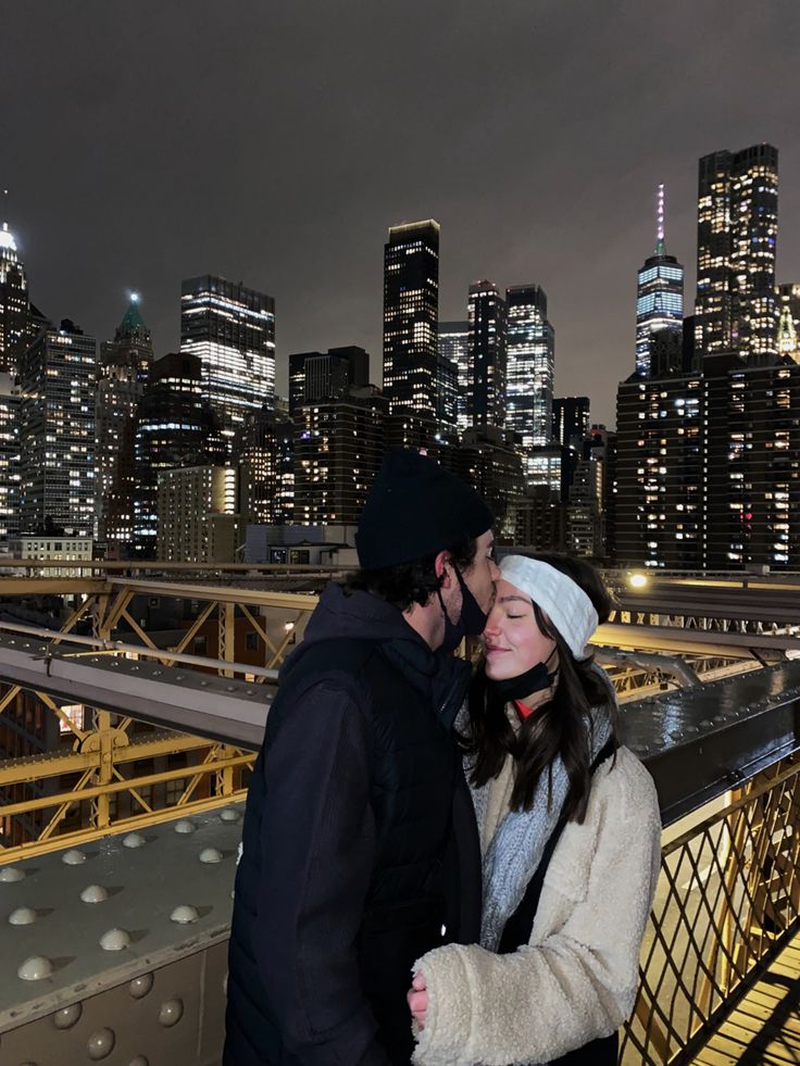 a man and woman standing next to each other in front of a cityscape