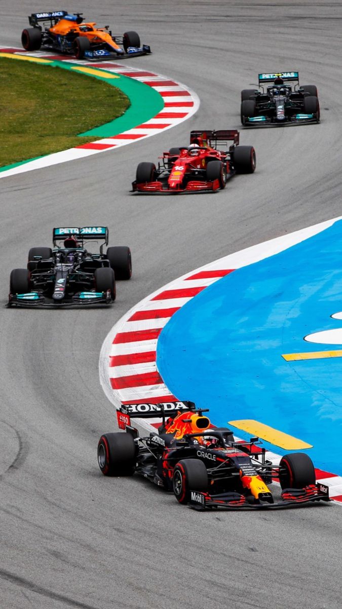 three red bull racing cars on a race track