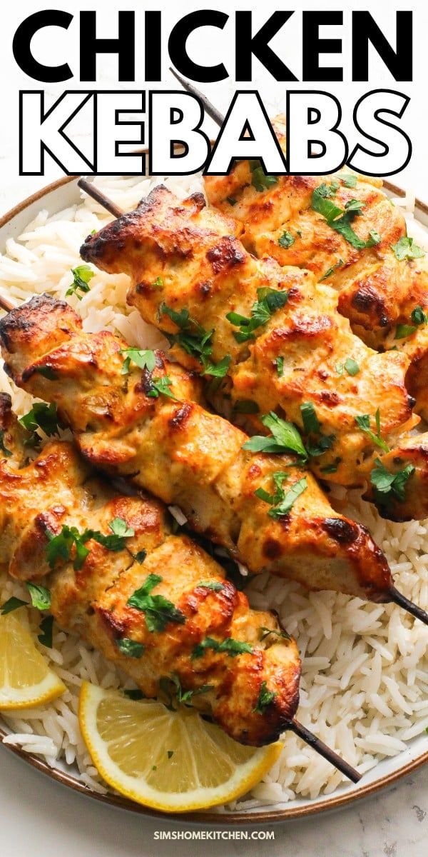 chicken kebabs with lemons and rice on a white plate, with the title above it