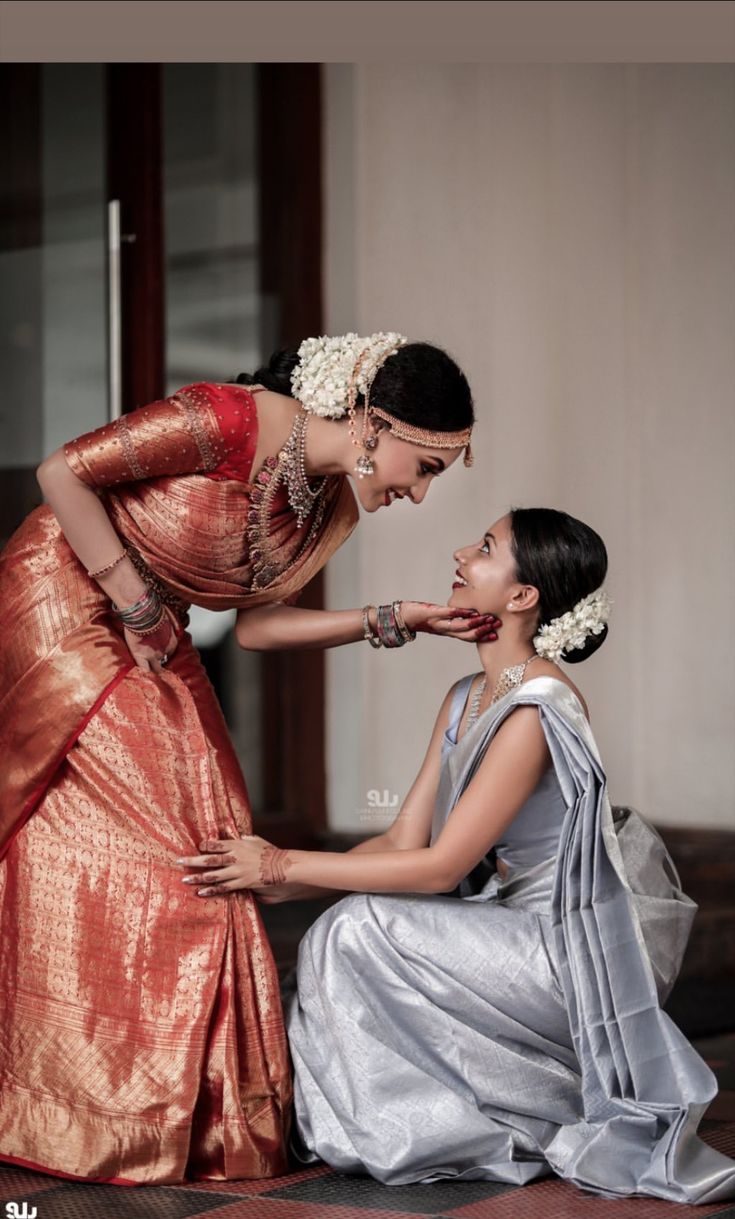 two women in dresses touching each other's lips