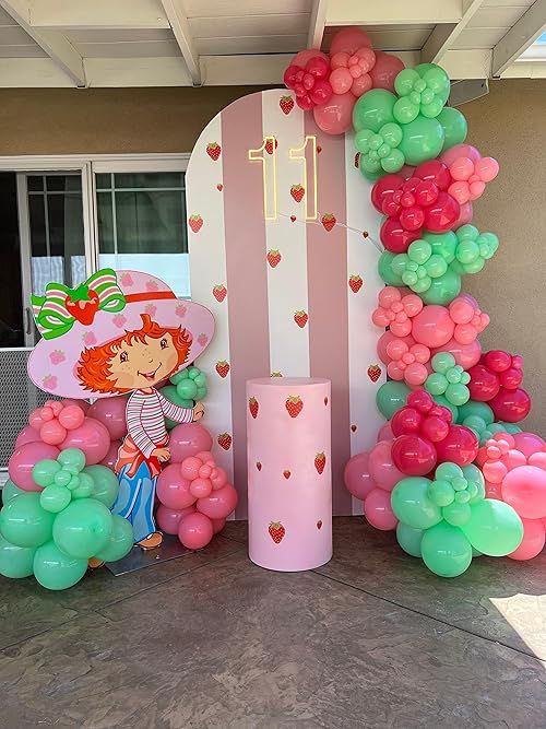 the balloon arch is decorated with pink, green and white balloons