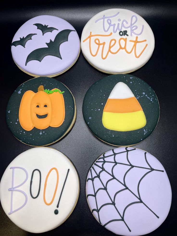 four decorated cookies with halloween designs on them