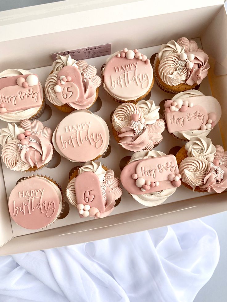 a box filled with cupcakes covered in pink frosting and decorated with flowers