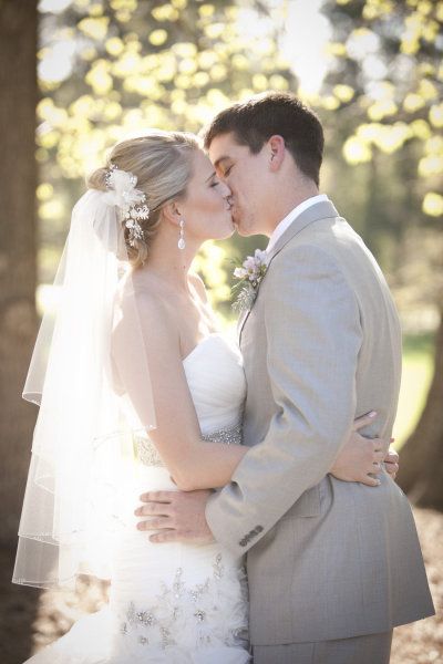 a bride and groom kissing in front of trees