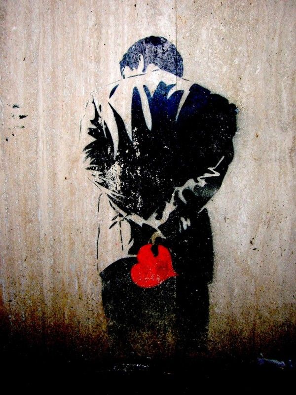 a painting on the side of a wall with a man holding a red ball in his hand