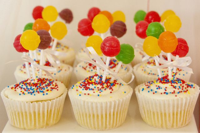 cupcakes with colorful candies and lollipops on top