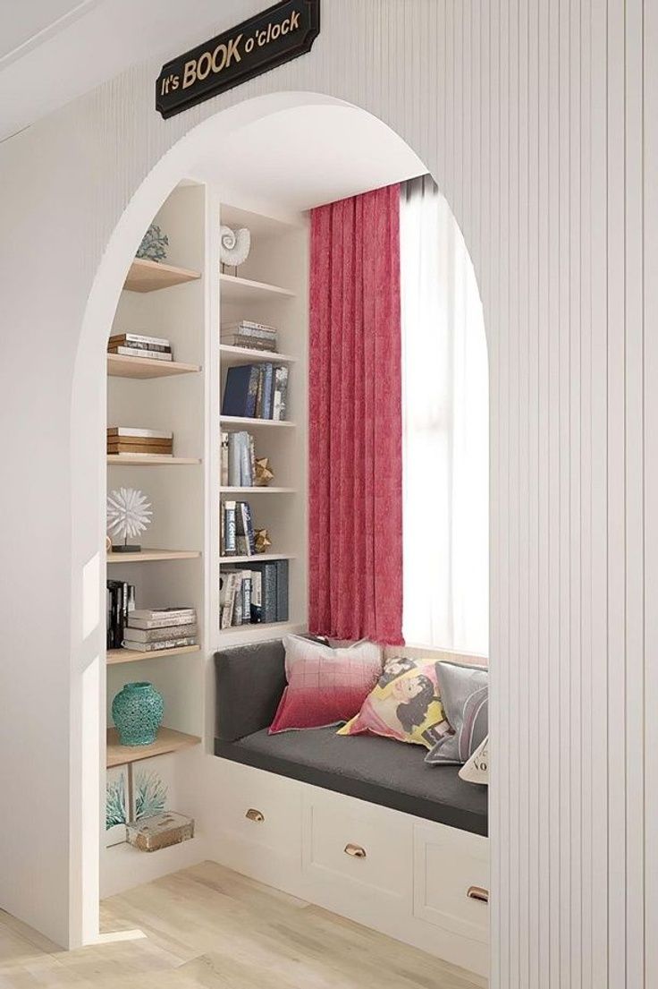 a room with a window seat and bookshelf