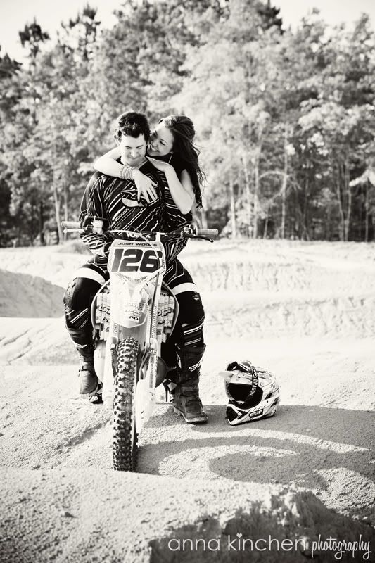 two people on a dirt bike with trees in the background