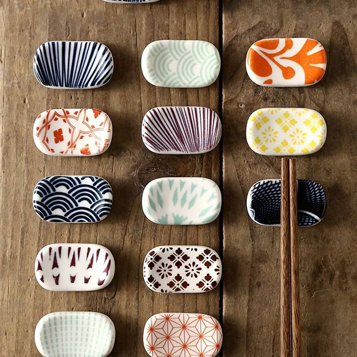 many different plates and chopsticks on a wooden table with chopsticks in the middle