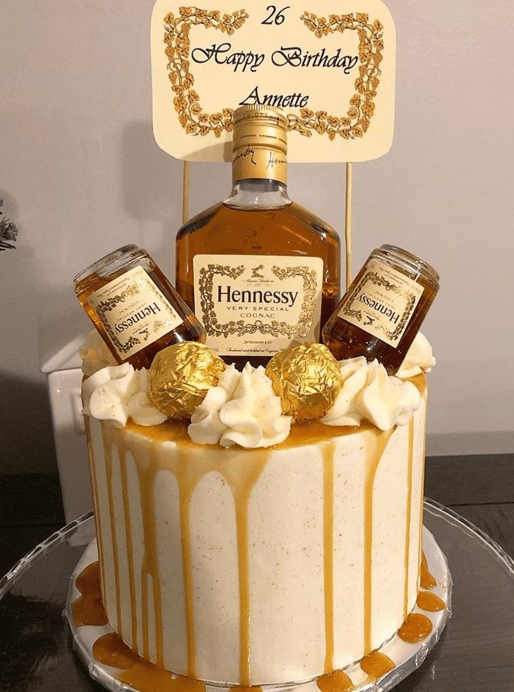 a cake decorated with an old fashioned bottle of hennesy and some chocolate candies