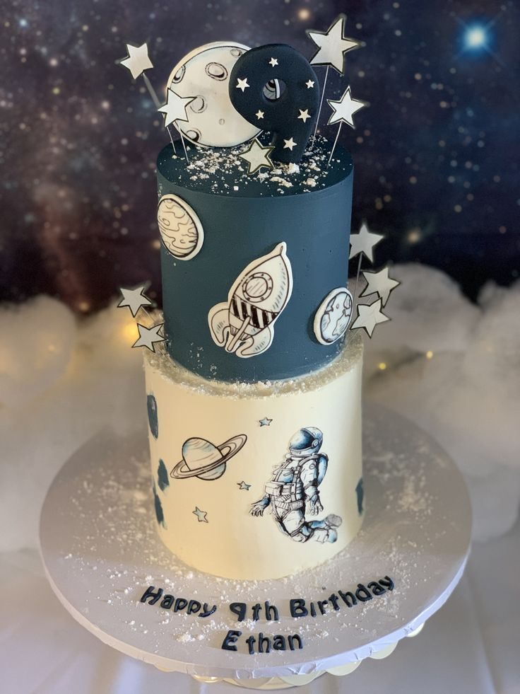 a three tiered birthday cake with stars and planets on it