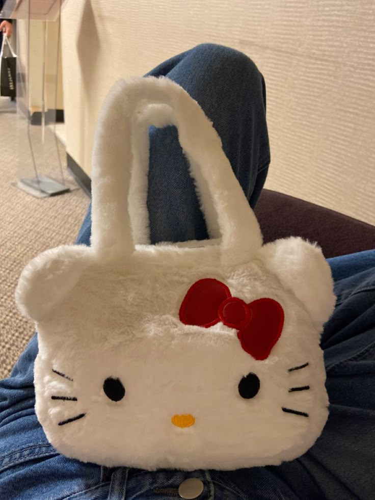 a hello kitty purse sitting on someone's lap