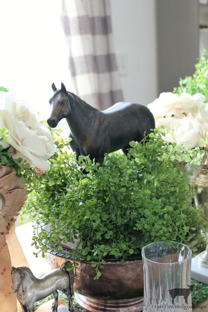 a horse figurine sitting on top of a potted plant