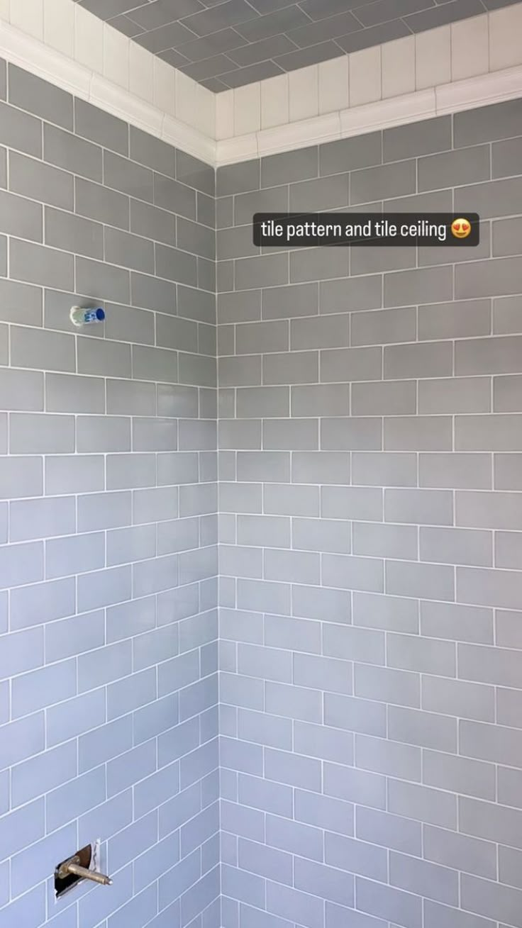 a white toilet sitting next to a shower in a tiled bathroom with gray walls and floor