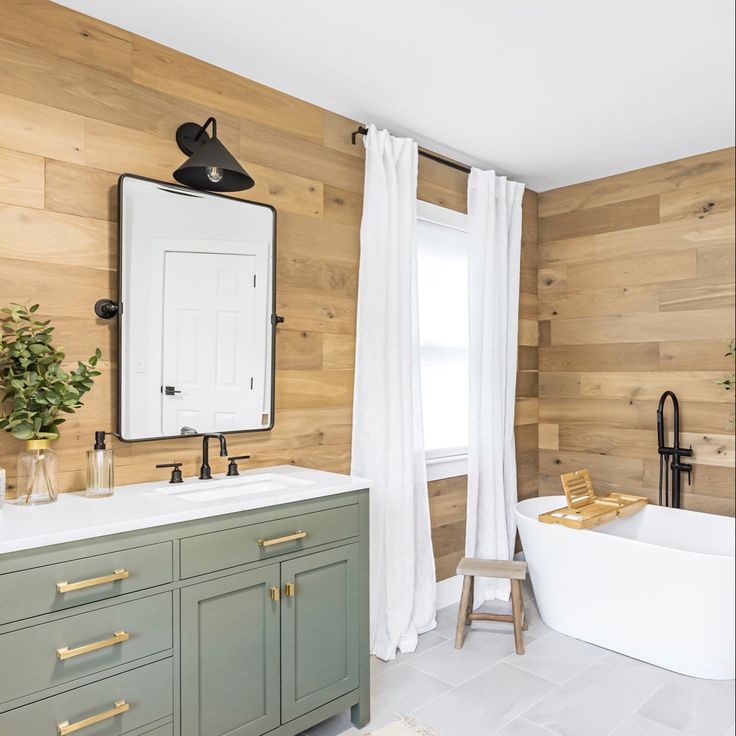 a bathroom with wood paneling and white fixtures, including a claw foot bathtub