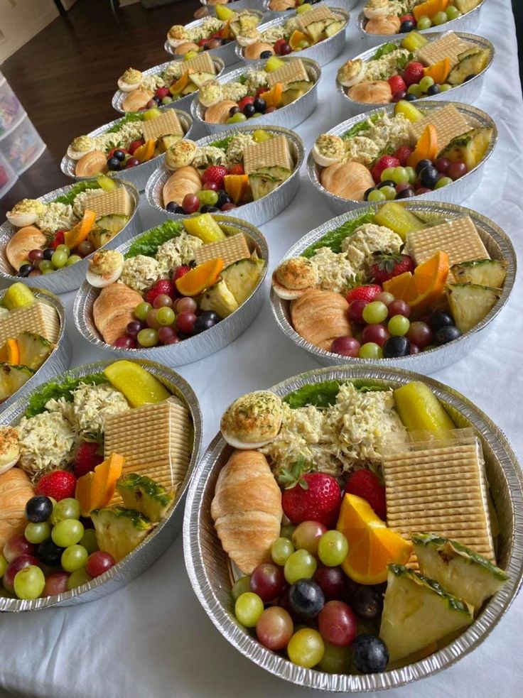 a table topped with lots of trays filled with different types of foods and desserts