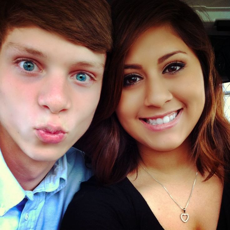 a young man and woman are posing for a photo in the back of a car