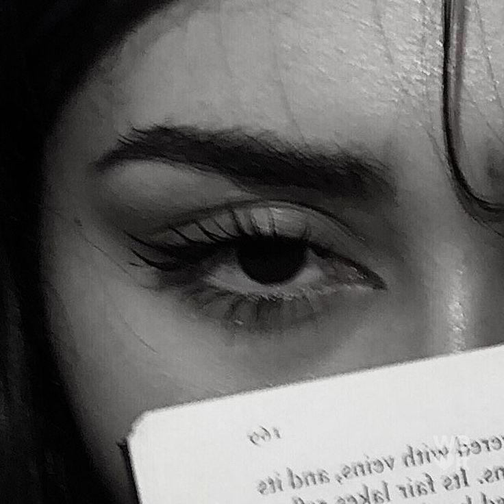 a close up of a person's eye with a piece of paper in front of their face