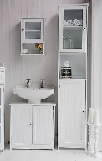 a bathroom with white furniture and accessories on the floor, including a sink and cabinet