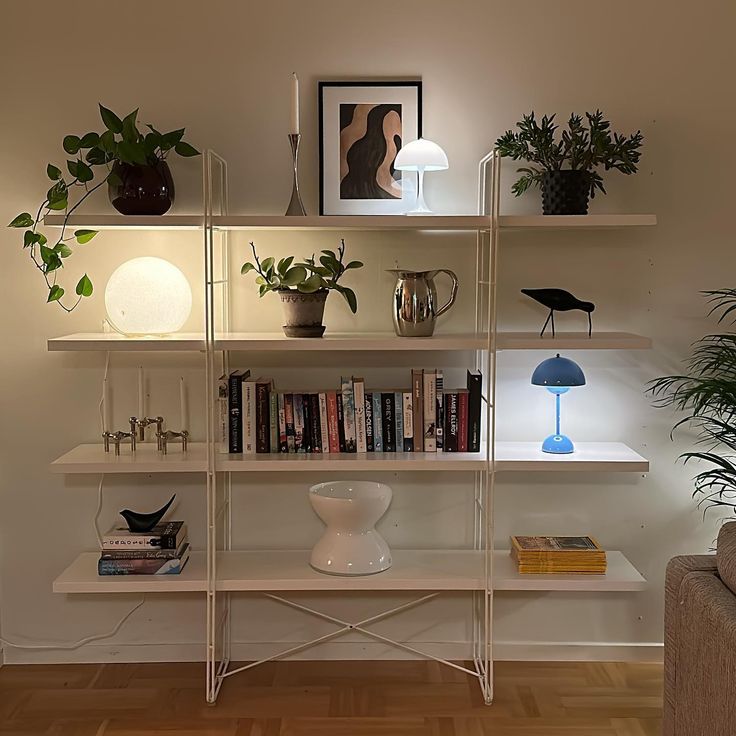 a living room filled with lots of furniture and plants on top of bookshelves