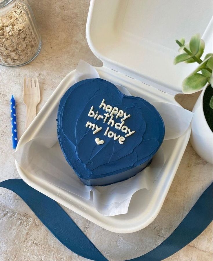 a blue heart shaped cake sitting on top of a white plate next to a fork