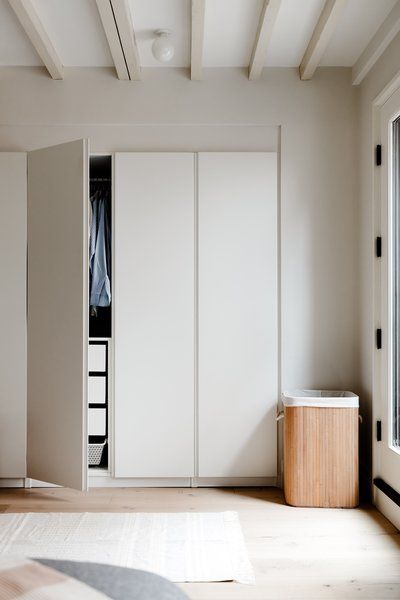 an empty bedroom with white closets and wooden floors, along with a large rug on the floor