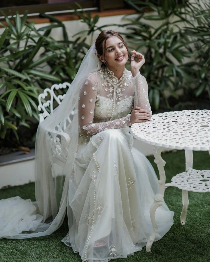 a woman in a wedding dress sitting at a table