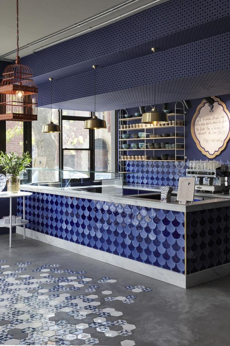 the interior of a restaurant with blue and white tiles on the floor, walls and ceiling