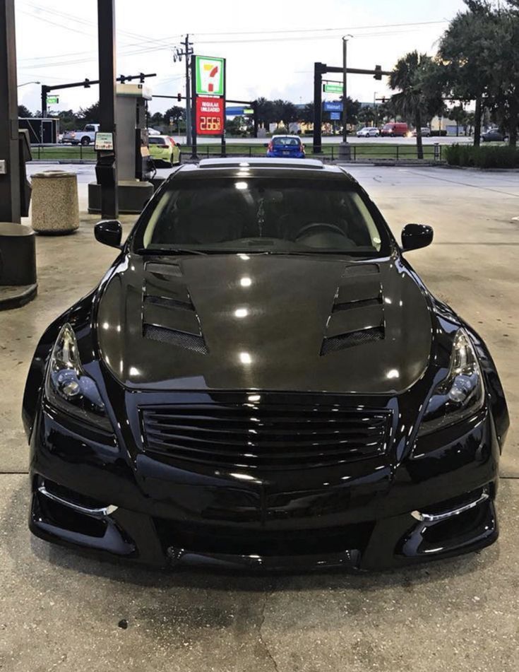 a black sports car parked in front of a gas station with no one around it