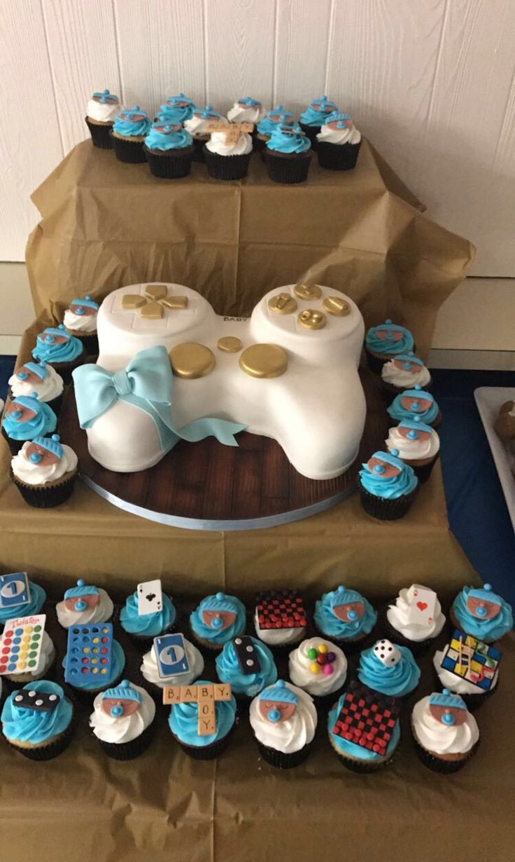 a table topped with lots of cupcakes covered in frosting and blue icing