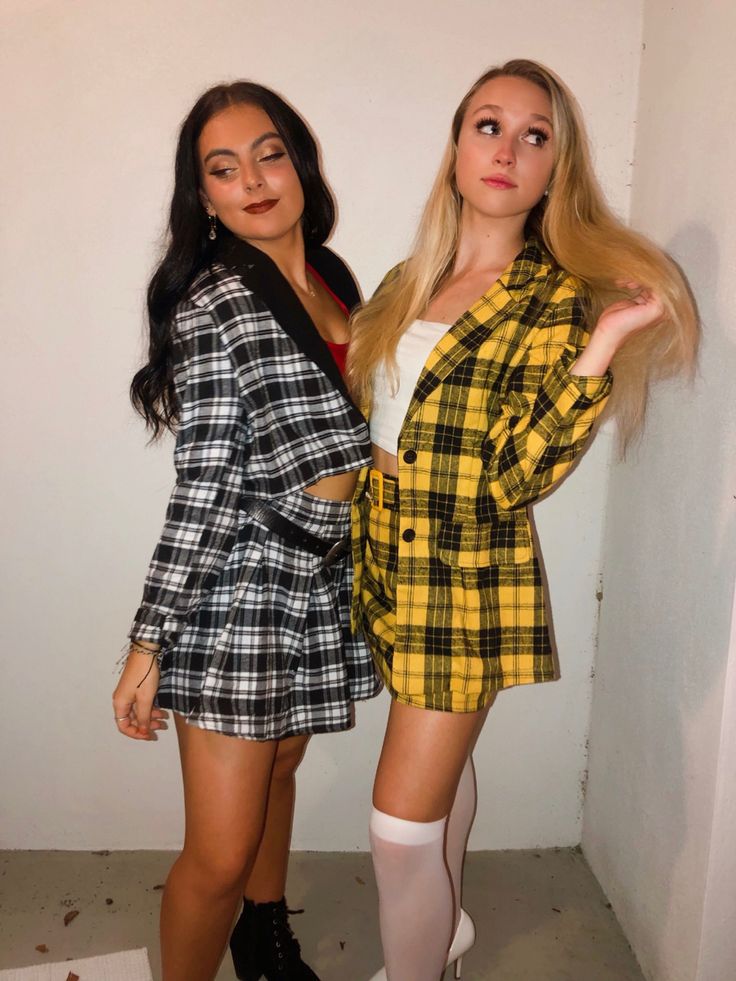 two women dressed in plaid outfits posing for the camera