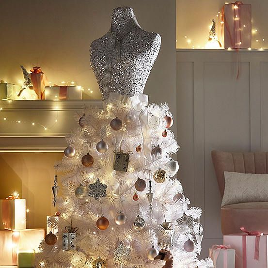 a white christmas tree decorated with silver and gold ornaments