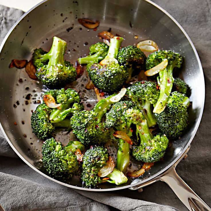 a pan filled with broccoli on top of a table